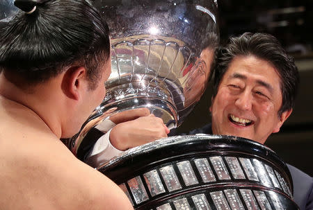 Japanese Prime Minister Shinzo Abe presents the Prime Minister’s Cup to wrestler Asanoyama, the winner of the Summer Grand Sumo Tournament at Ryogoku Kokigikan Sumo Hall in Tokyo, Japan May 26, 2019. REUTERS/Jonathan Ernst