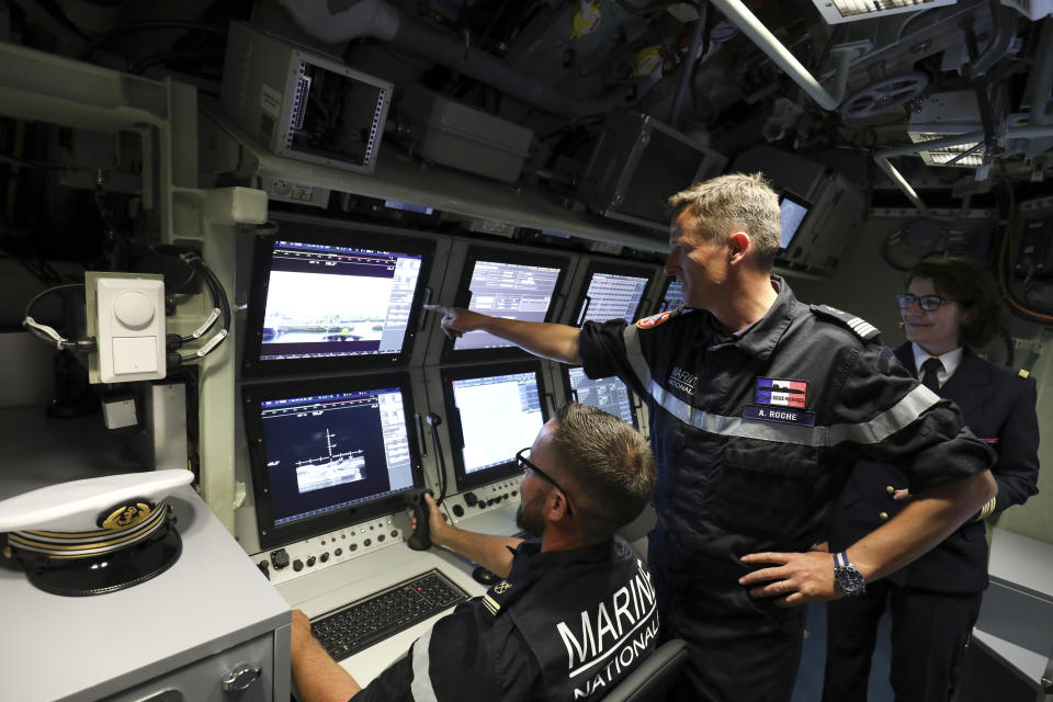 FILE - In this July 12, 2019 file photo, French navy commander Axel Roch poses in the navigation and operations center in the new nuclear-powered submarine "Suffren" in Cherbourg, north-western France. Stealthily cruising the ocean deeps, deliberately hiding from the world now in turmoil, the crews of nuclear-armed submarines may be among the last pockets of people anywhere who are still blissfully unaware of how the coronavirus pandemic is turning life upside down. The new coronavirus causes mild or moderate symptoms for most people, but for some, especially older adults and people with existing health problems, it can cause more severe illness or death. (Ludovic Marin/Pool via AP, File)