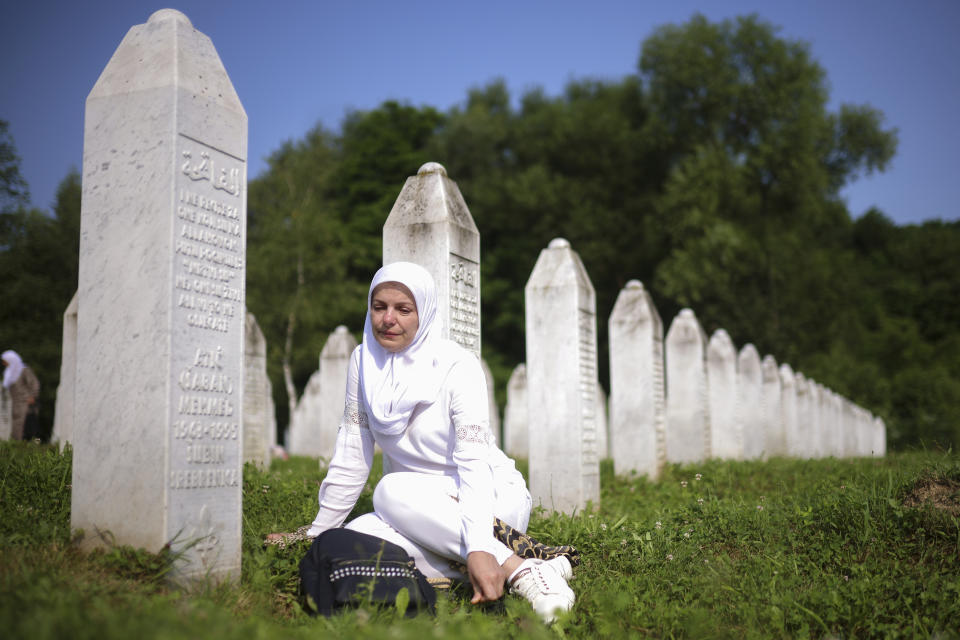 A Bosnian muslim woman mourns next to the grave of her relative, victim of the Srebrenica genocide, at the Memorial Centre in Potocari, Bosnia, Tuesday, July 11, 2023. Thousands gather in the eastern Bosnian town of Srebrenica to commemorate the 28th anniversary on Monday of Europe's only acknowledged genocide since World War II. (AP Photo/Armin Durgut)