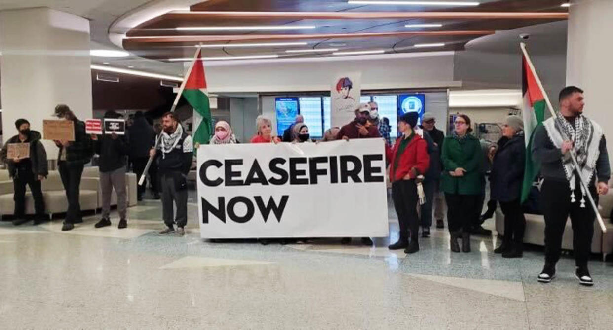 Protesters hold a sign that reads 