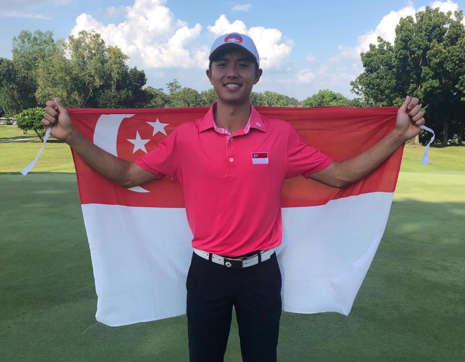 Singapore golfer James Leow poses with the national flag after winning the men's individual gold at SEA Games. (PHOTO: Singapore Golf Association)