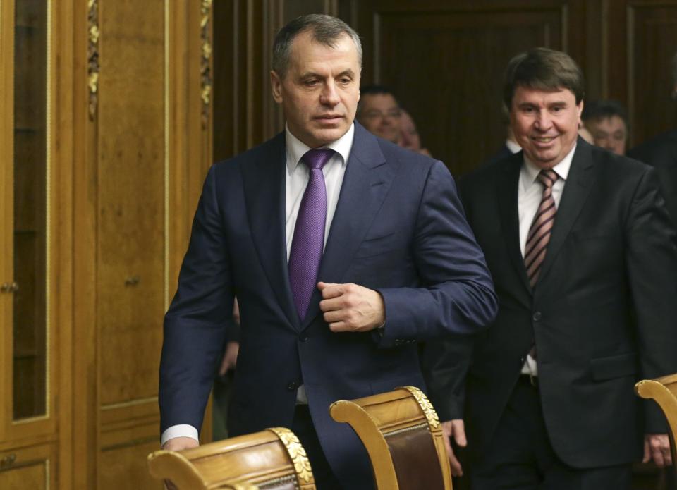 El primer ministro de Crimea, Serguei Aksionov, centro, entra a una sala antes de la reunión con el Parlamento ruso en Moscú, el viernes 7 de marzo de 2014. (AP Foto/Alexander Shalgin)