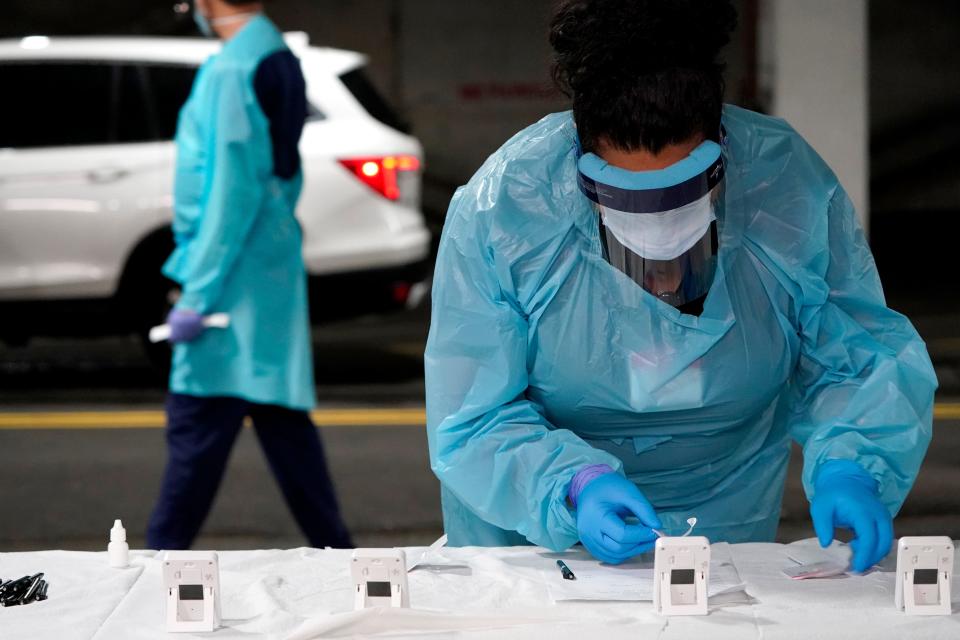 A nurse checks on the status of a rapid COVID-19 test at a drive-through testing site in West Nyack, in this Nov. 30, 2020 file photo.