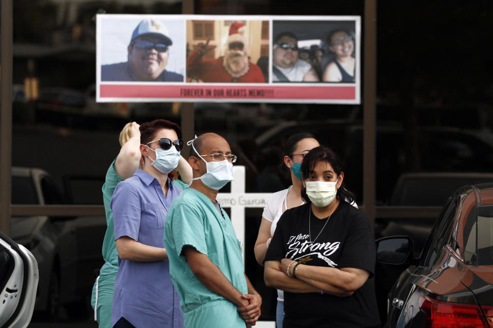 In this Thursday, May 21, 2020 photo, mourners wear masks to prevent the spread of COVID-19 at a memorial for Walmart shooting victim Guillermo "Memo" Garcia, in El Paso, Texas. Garcia died after nine months in at Del Sol Medical Center. At his memorial in the hospital parking lot, medical staff, family and friends wore masks to prevent the spread of COVID-19. Some mourners wore "El Paso Strong" T-shirts. The slogan united residents after the shooting, but hasn't caught on in the COVID-19 crisis. (AP Photo/Cedar Attanasio)