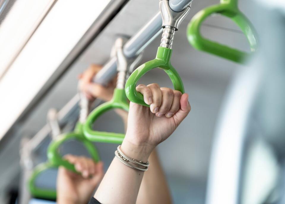 People hold onto the handrails in the Reseau express metropolitain (REM) light rail system during its inaugural run from Brossard to Gare Centrale on Friday, July 28, 2023. 