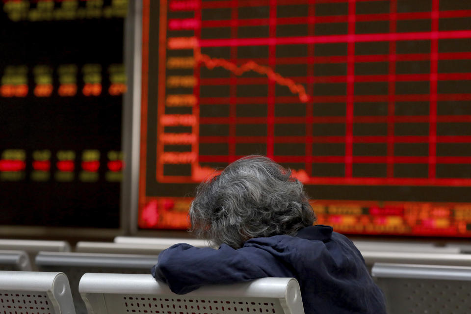 A woman rests as she monitors stock prices at a brokerage in Beijing on Tuesday, June 25, 2019. Major Asian stock markets declined Tuesday as traders looked ahead to a meeting between the American and Chinese presidents amid hopes for renewed trade talks. (AP Photo/Ng Han Guan)