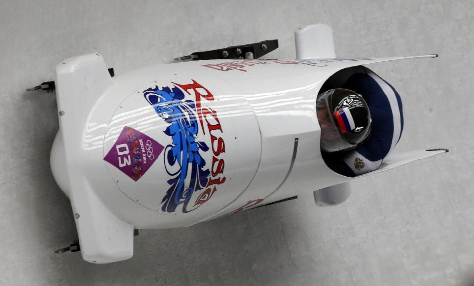 The team from Russia RUS-1, piloted by Alexander Zubkov and brakeman Alexey Voevoda, take a curve during the men's two-man bobsled competition at the 2014 Winter Olympics, Sunday, Feb. 16, 2014, in Krasnaya Polyana, Russia. (AP Photo/Michael Sohn)