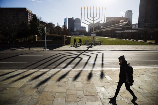 A woman passes by a menorah on Independence Mall in Philadelphia ahead of the second night of Hanukkah. Matt Rourke / AP