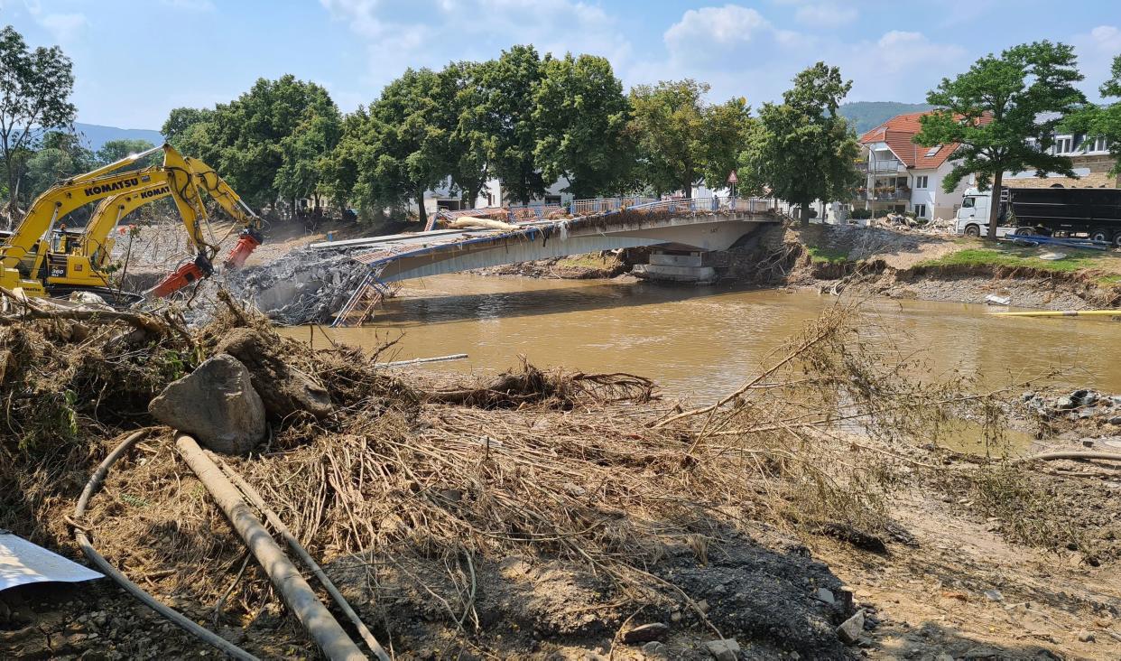 Workers use heavy machines to tear down a damaged bridge in the flood-hit town of Ahrweiler, Germany, on Friday.