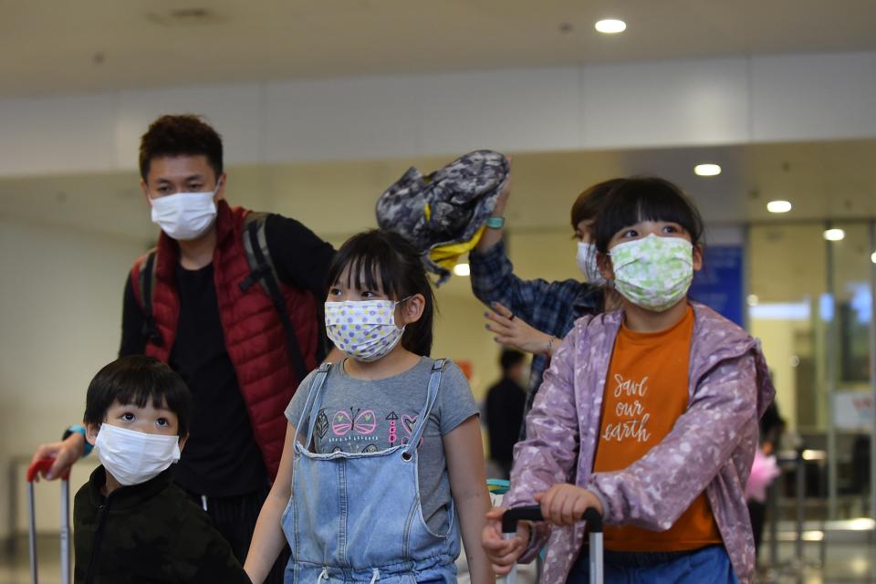 This picture taken on February 2, 2020 shows travellers wearing protective facemasks at Noi Bai international airport in Hanoi. - Vietnam suspended mainland China flights over virus fears as it spread to two dozen nations and killed 259 people in China where it originated in the city of Wuhan. (Photo by Nhac NGUYEN / AFP) (Photo by NHAC NGUYEN/AFP via Getty Images)