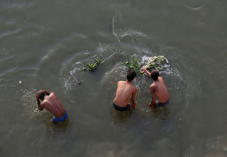 Men bathe in the river Ganges in Kanpur, India, April 3, 2017. REUTERS/Danish Siddiqui