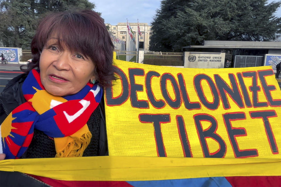Protester Tseten Zoechbauer holds up a "Decolonize Tibet" banner outside the U.N. office in Geneva, Switzerland, Tuesday, Jan. 23, 2024, at a rally supporting Tibet and the Uyghur minority in China. The demonstration outside the U.N. office in Geneva came as China's government faced a regular review of its human rights record at a Human Rights Council meeting inside. (AP Photo/Jamey Keaten)