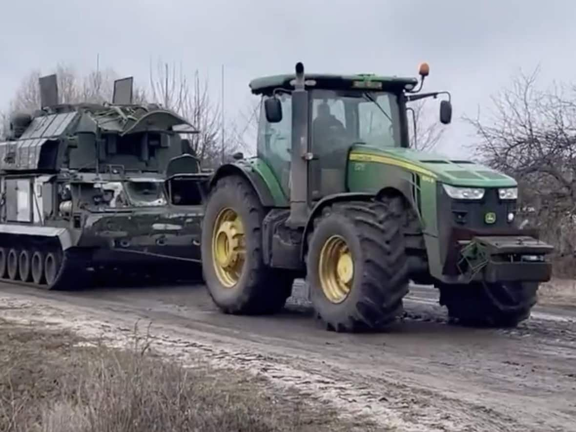 In what has become a recurring theme on the internet during the war in Ukraine, a tractor tows an abandoned Russian vehicle in southern Ukraine. (RALee85/Twitter - image credit)