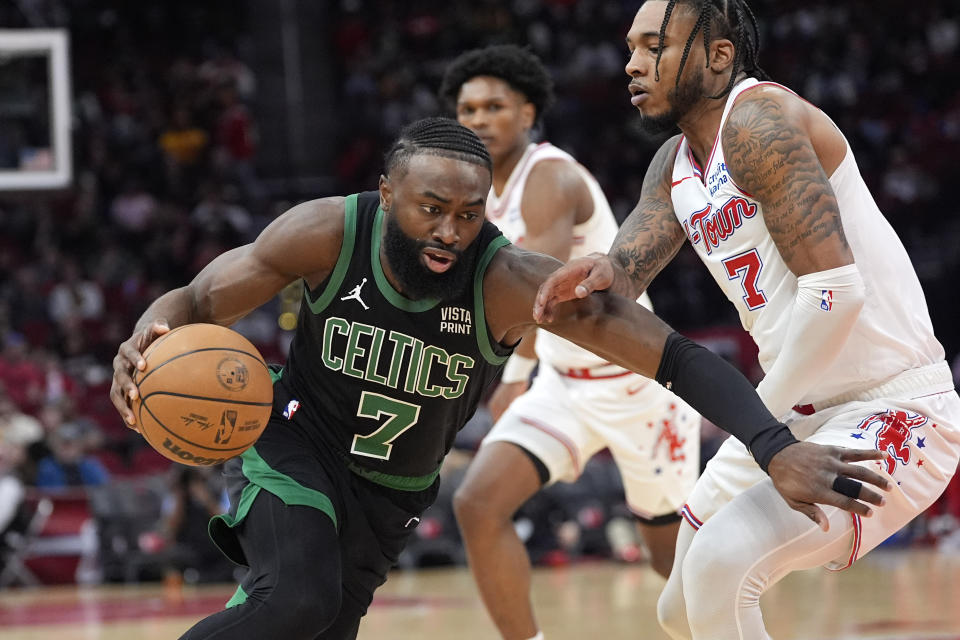 Boston Celtics' Jaylen Brown, left, drives toward the basket as Houston Rockets' Cam Whitmore defends during the first half of an NBA basketball game Sunday, Jan. 21, 2024, in Houston. (AP Photo/David J. Phillip)