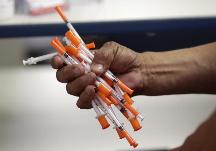 FILE - In this May 6, 2019 photo file photo an injection drug user, deposits used needles into a container at the IDEA exchange, in Miami. National data is incomplete, but available information suggests U.S. drug overdose deaths are on track to reach an all-time high. Addiction experts blame the pandemic, which has left people stressed and isolated, disrupted treatment and recovery programs, and contributed to an increasingly dangerous illicit drug supply. (AP Photo/Lynne Sladky, Fie)