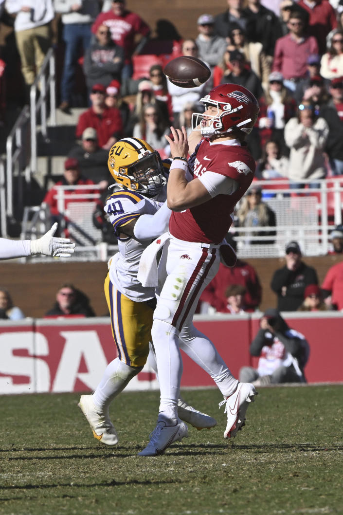LSU linebacker Harold Perkins Jr. (40) knocks the ball away from Arkansas quarterback Cade Fortin (10) during the second half of an NCAA college football game Saturday, Nov. 12, 2022, in Fayetteville, Ark. The play was called a fumble and recovery by LSU but was reversed after officials reviewed the play. (AP Photo/Michael Woods)