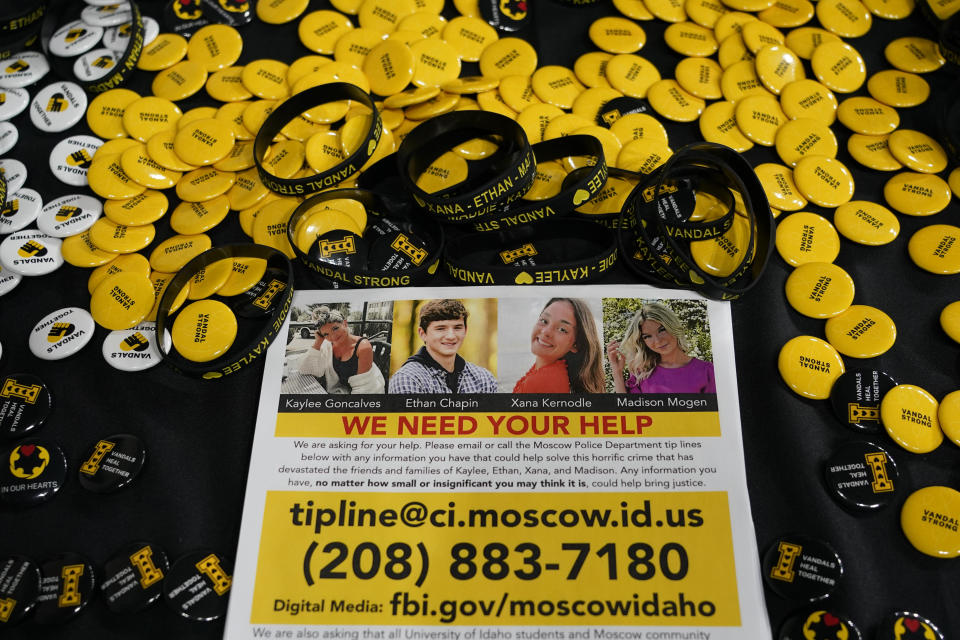 FILE - A flyer seeking information about the killings of four University of Idaho students who were found dead is displayed on a table along with buttons and bracelets on Nov. 30, 2022, during a vigil in memory of the victims in Moscow, Idaho. Attorneys for Bryan Kohberger, the man charged with stabbing four University of Idaho students to death, are expected to ask a judge to move the trial away from the rural college town where the slayings occurred. (AP Photo/Ted S. Warren, File)