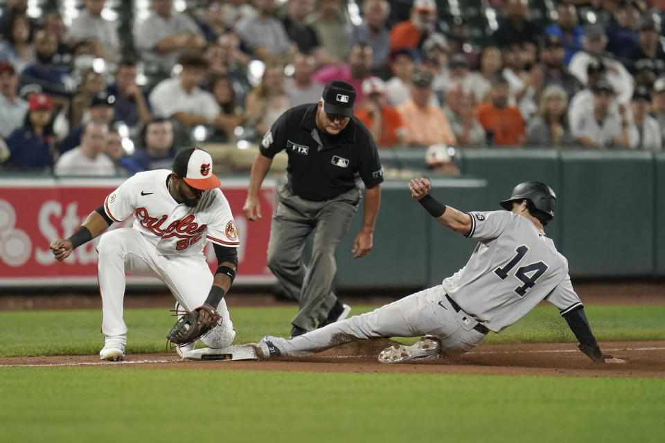 New York Yankees' Tyler Wade, right, steals third base as Baltimore Orioles third baseman Kelvin Gutierrez tries to apply a tag during the ninth inning of a baseball game, Wednesday, Sept. 15, 2021, in Baltimore. (AP Photo/Julio Cortez)