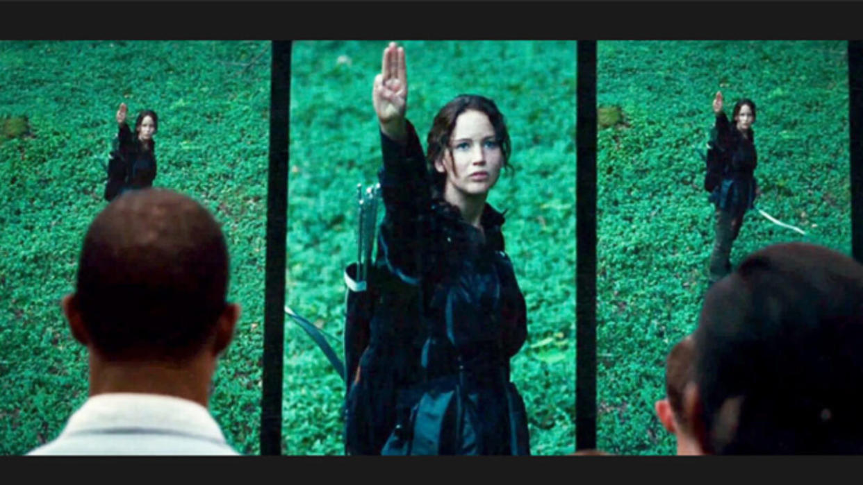  Jennifer Lawrence as Katniss doing three finger salute in The Hunger Games 