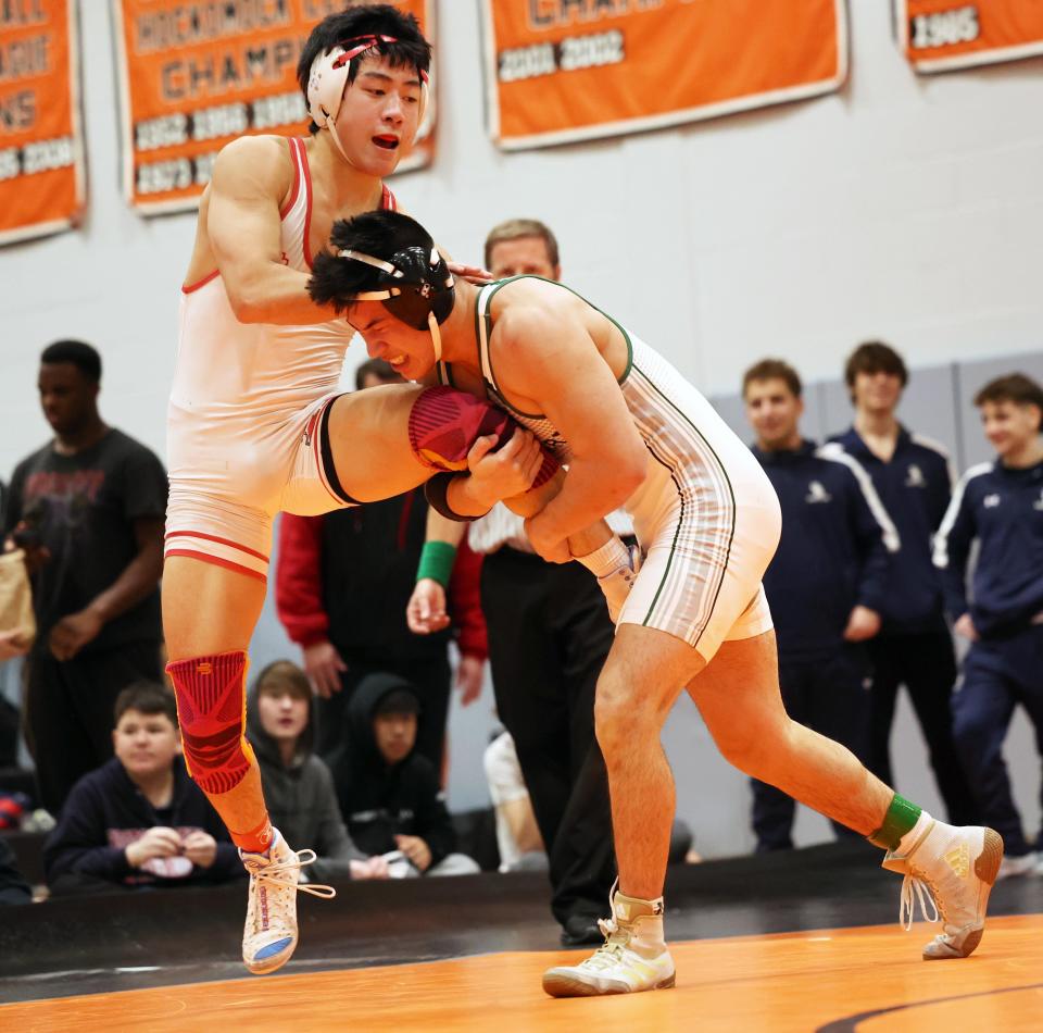 From left, Hingham's Aidan Chan, won the 157 pound finals wrestling match versus Duxbury's Nick Bizzozero during Division 2 South Sectionals on Saturday, Feb. 10, 2024.