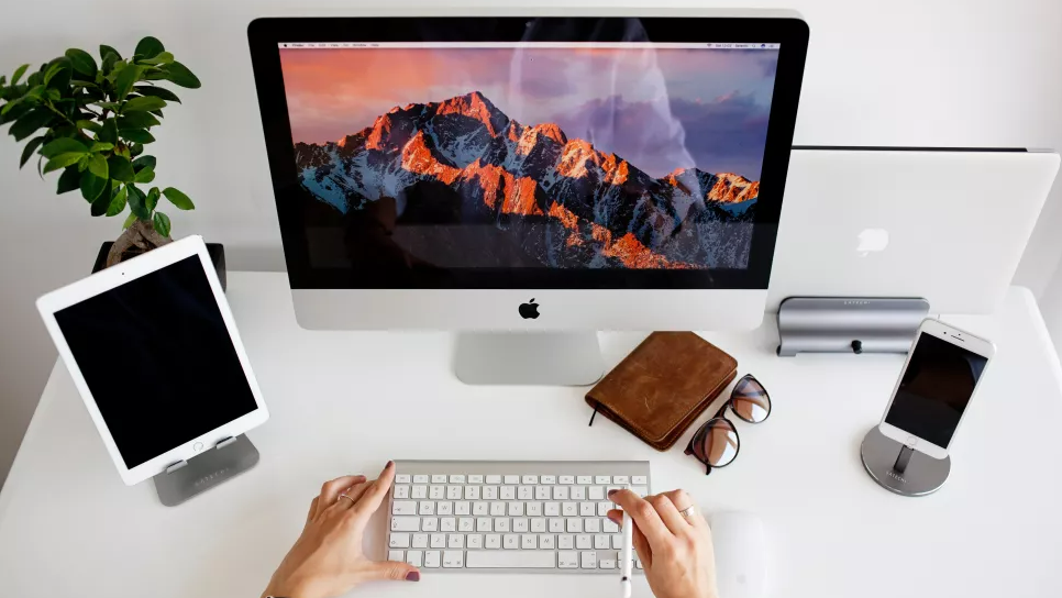  Apple devices being used at a desk 