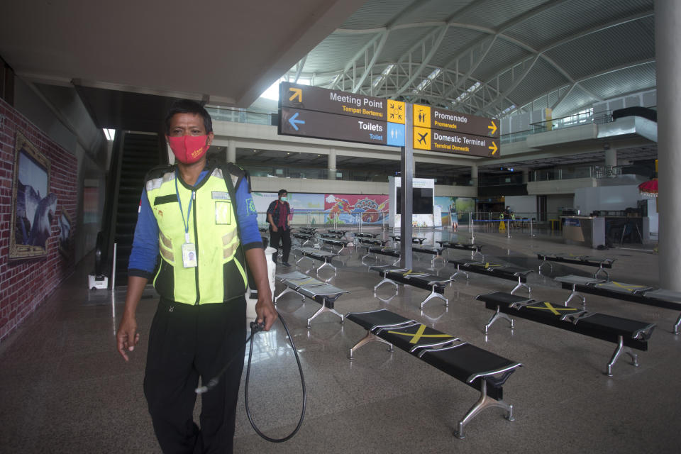 An airport worker walks at the arrival hall of International Ngurah Rai Airport in Bali, Indonesia, Thursday, Oct. 14, 2021. The Indonesian resort island of Bali welcomed international travelers to its shops and white-sand beaches for the first time in more than a year Thursday - if they're vaccinated, test negative, hail from certain countries, quarantine and heed restrictions in public. (AP Photo/Firdia Lisnawati)