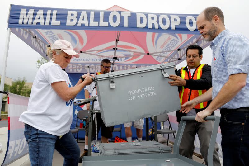 FILE PHOTO: Election workers take away a ballot box full of votes at a drive-through mail-in ballot return drop set-up outside the Registrar of Voters office in San Diego