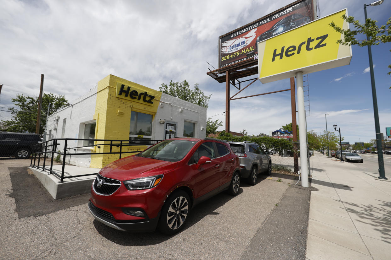 Rental vehicles are parked outside a closed Hertz car rental office Saturday, May 23, 2020, in south Denver. (AP Photo/David Zalubowski)