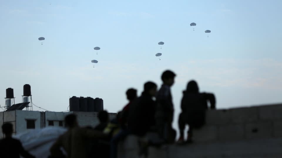 People watch as the US military carries out its first aid drop over Gaza on March 2, 2024. - Kosay Al Nemer/Reuters