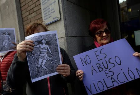 People shout slogans while holding signs during a protest outside the courts of Aviles, after a Spanish court sentenced five men accused of the group rape of an 18-year-old woman at the 2016 San Fermin bull-running festival each to nine years in prison for the lesser charge of sexual abuse, in Aviles, Spain, April 27, 2018. The sign reads: "It is not abuse, it is rape". REUTERS/Eloy Alonso