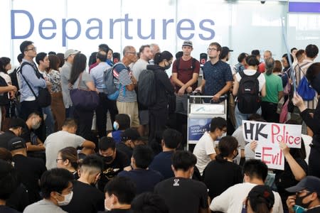 Passengers wait at the departure gate of Hong Kong airport as anti-extradition bill protesters occupy the floor, in Hong Kong