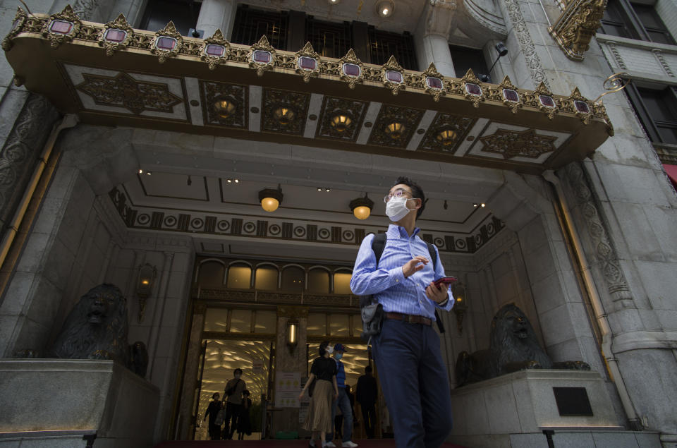A man wearing a face mask pauses as he comes out of a department store in Tokyo during a state of emergency on Thursday, Sept. 30, 2021. On Friday, Oct. 1, 2021, Japan fully came out of a coronavirus state of emergency for the first time in more than six months as the country starts gradually easing virus measures to help rejuvenate the pandemic-hit economy as the infections slowed. (AP Photo/Hiro Komae)