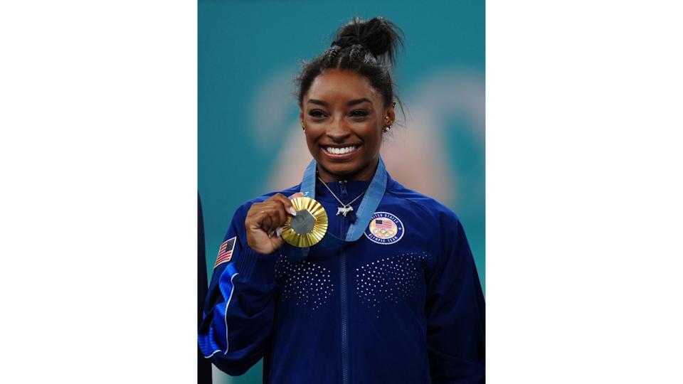 Simone Biles with her gold medal and 'GOAT' necklace following the Women's All-Around Final at the Bercy Arena