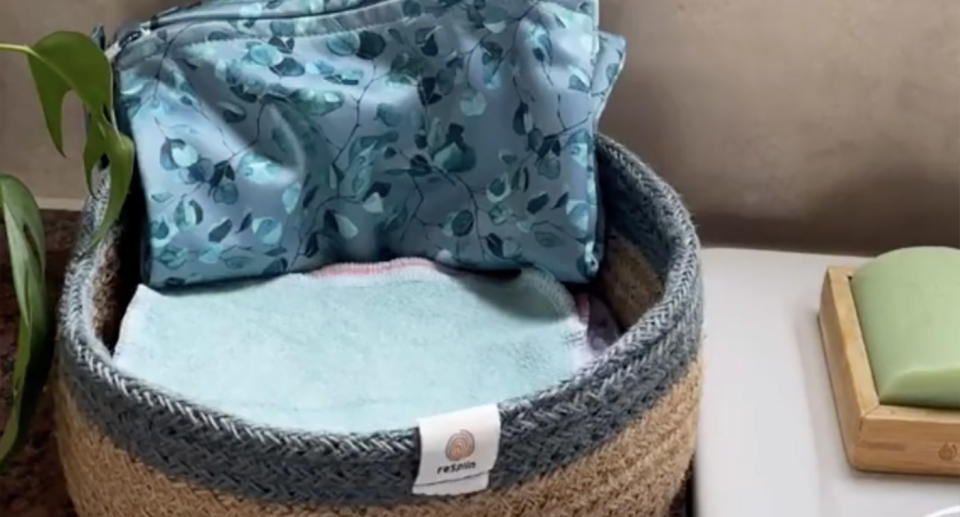 Toilet paper alternative cloths in basket on bathroom shelf