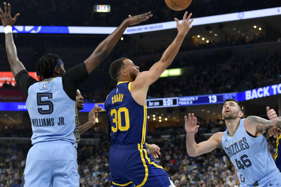 Golden State Warriors guard Stephen Curry (30) shoots between Memphis Grizzlies guards Vince Williams Jr. (5) and John Konchar (46) in the first half of an NBA basketball game Friday, Feb. 2, 2024, in Memphis, Tenn. (AP Photo/Brandon Dill)