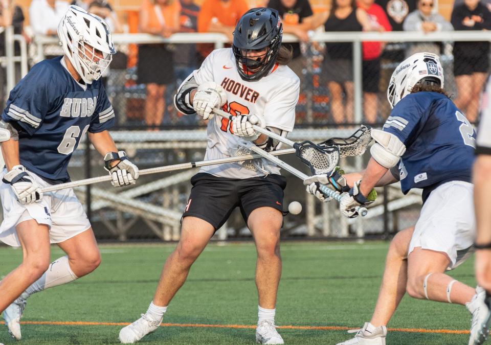 Hoover’s Cole Rembielak looses the ball to Hudson defenders Lucas Offredo (left) and Ethan Moore in a Division I regional semifinal, Tuesday, May 23, 2023.