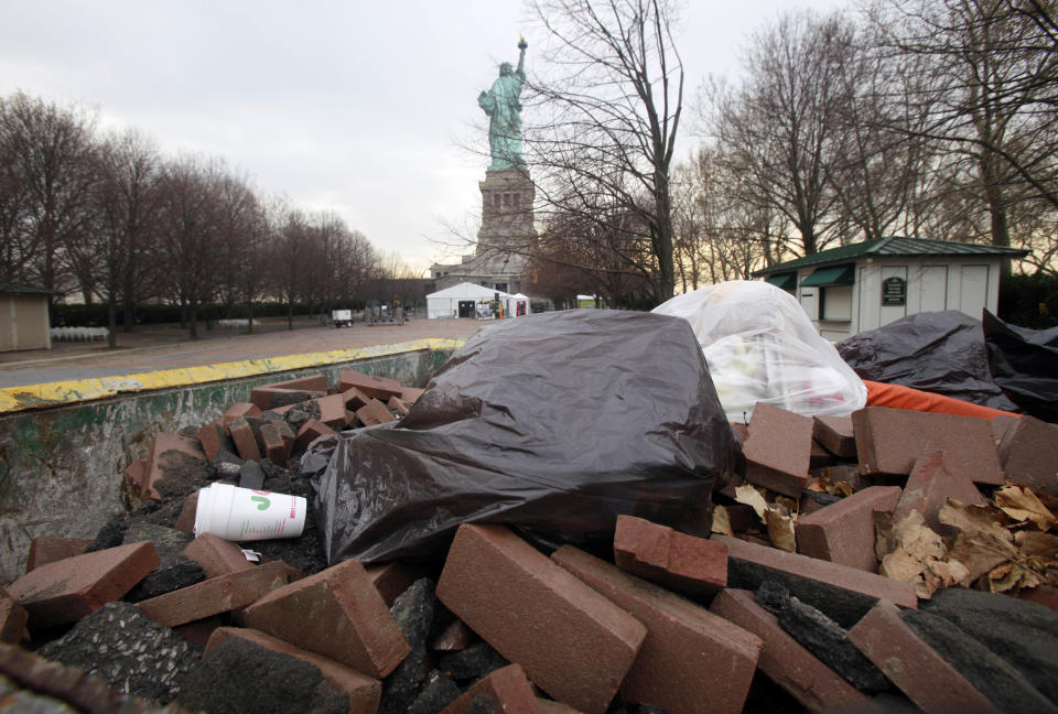 Bricks from the walkway that surrounds Liberty Island are collected in a Dumpster, in New York, Friday, Nov. 30, 2012. Tourists in New York will miss out for a while on one of the hallmarks of a visit to New York, seeing the Statue of Liberty up close. Though the statue itself survived Superstorm Sandy intact, damage to buildings and Liberty Island's power and heating systems means the island will remain closed for now, and authorities don't have an estimate on when it will reopen. (AP Photo/Richard Drew)