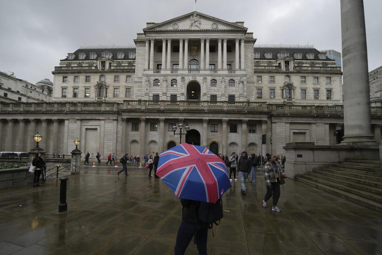 interest rate FILE - A woman with an umbrella stands in front of the Bank of England, at the financial district in London, Thursday, Nov. 3, 2022. Britain’s economy shrank in the three months to September, official statistics said Friday, Nov. 11, 2022, as forecasters warned of many months of contraction to come. The Office for National Statistics said gross domestic product fell by 0.2% between July and September, a smaller-than-expected contraction that nevertheless is seen to signal the start of a long recession. (AP Photo/Kin Cheung, File)