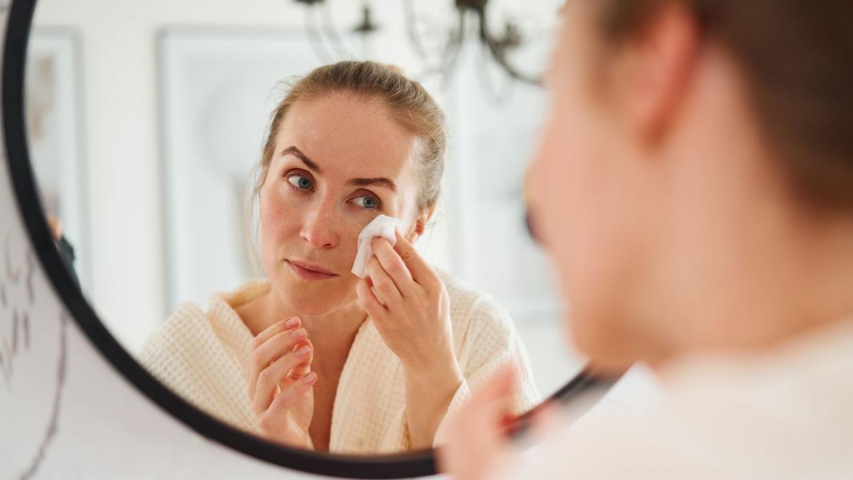 woman cleaning face in bathroom