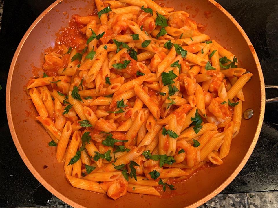 The shrimp, pasta, and sauce all mixed together, with parsley on top