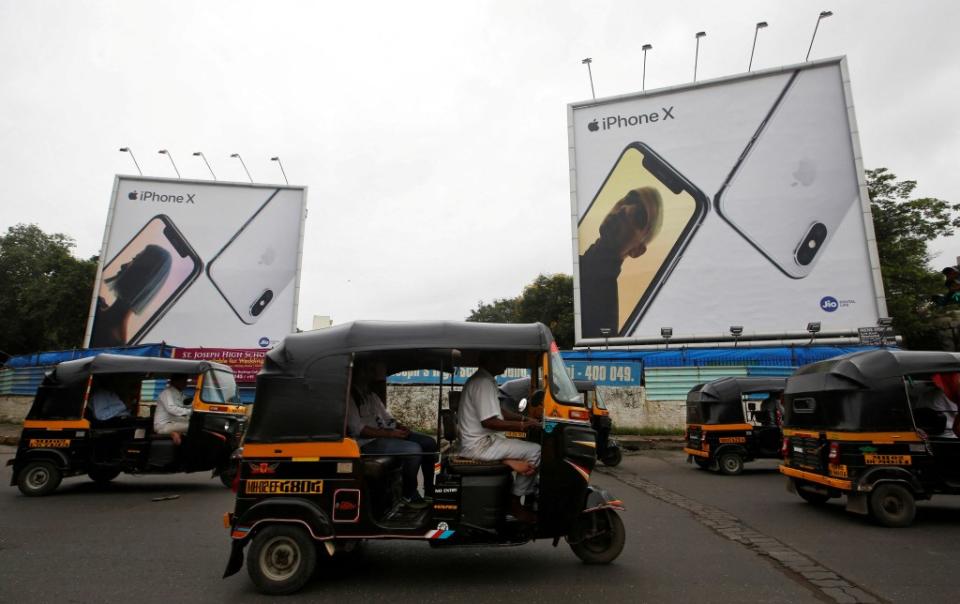 Auto-rickshaws driving past billboards advertising Apple’s iPhone X in Mumbai, India on July 27, 2018. REUTERS