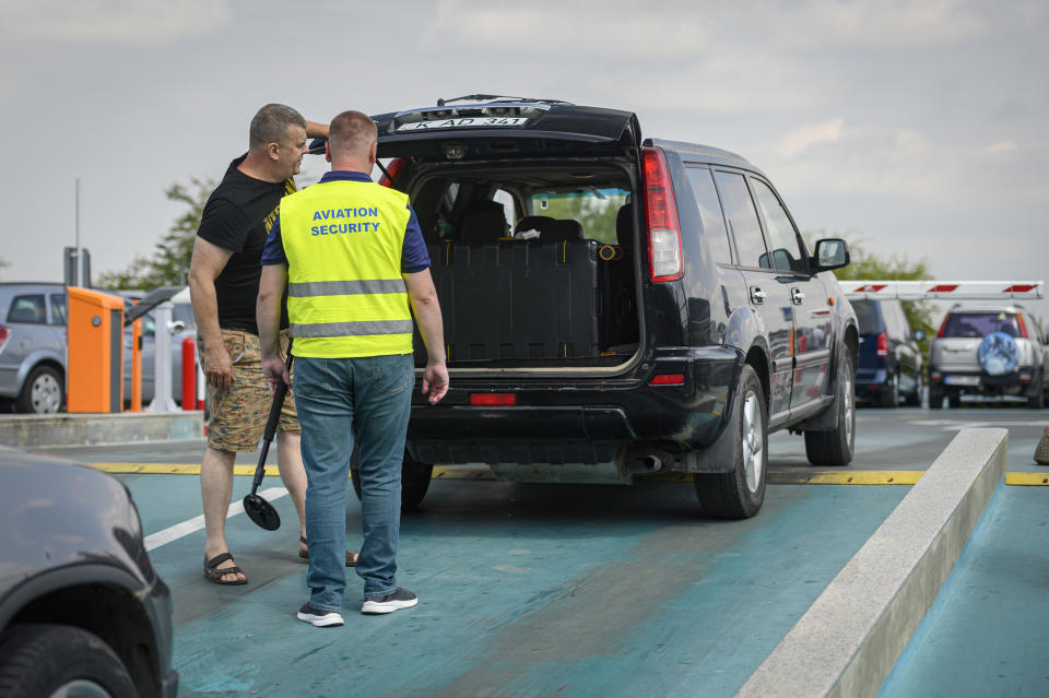 A member of the security personnel checks a vehicle for explosive devices at the international airport in Chisinau, Moldova, Tuesday, Aug. 16, 2022. Over the last two months non-European Union Moldova, which shares a border with war-torn Ukraine, has been plagued by scores of bomb threats that have wreaked havoc on the resources of the already overstretched authorities. (AP Photo/Cristian Straista)