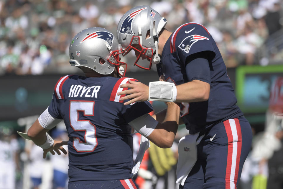 New England Patriots quarterback Mac Jones, right, celebrates a touchdown with back-up quarterback Brian Hoyer during the second half of an NFL football game against the New York Jets, Sunday, Sept. 19, 2021, in East Rutherford, N.J. (AP Photo/Bill Kostroun)