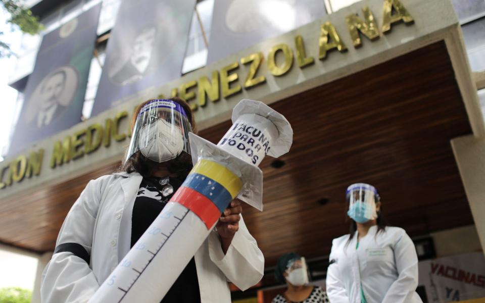 A doctor holds a syringe made from paper as doctors protest as they demand all healthcare workers to be vaccinated against the coronavirus disease, at the Venezuelan Medical Federation headquarter in Caracas, Venezuela -  MANAURE QUINTERO / REUTERS