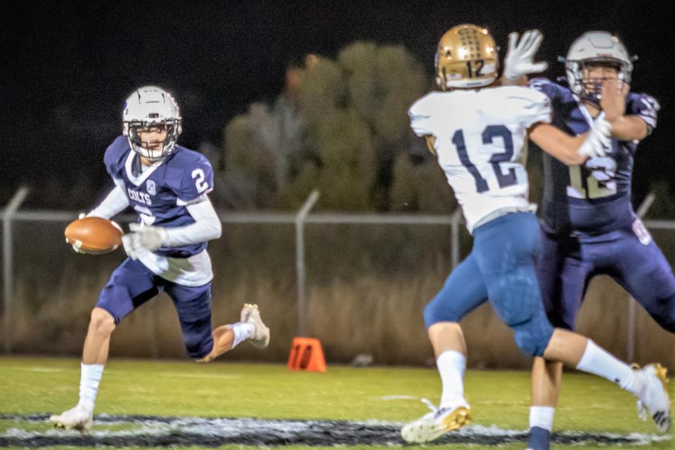 Silver High School running back Aaron Granado (2) looks downfield as he attempts to get past Ruidoso's Cooper Pritchett (12) during a football game Friday, Oct. 29, 2021 at Silver High School.