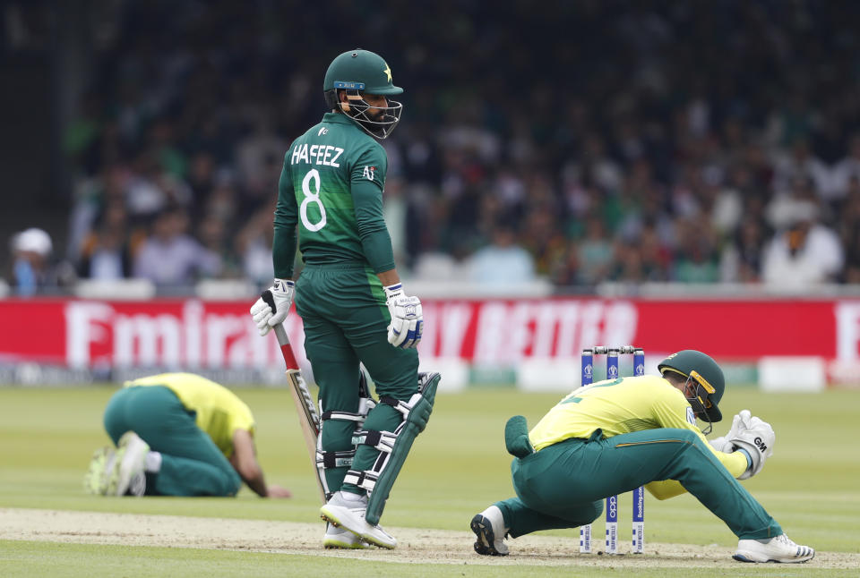 Pakistan's Mohammad Hafeez looks round after South Africa's wicketkeeper Quinton de Kock, right and bowler South Africa's Imran Tahir, react during their Cricket World Cup match between Pakistan and South Africa at Lord's cricket ground in London, Sunday, June 23, 2019. (AP Photo/Alastair Grant)