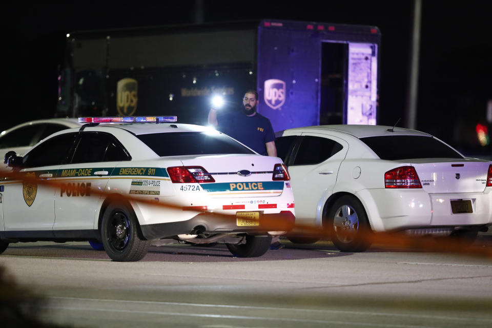 An FBI official investigates the scene of a shooting, Thursday, Dec. 5, 2019, in Miramar, Fla. Four people, including a UPS driver, were killed Thursday after robbers stole the driver’s truck and led police on a chase that ended in gunfire at a busy Florida intersection during rush hour, the FBI said. (AP Photo/Brynn Anderson)