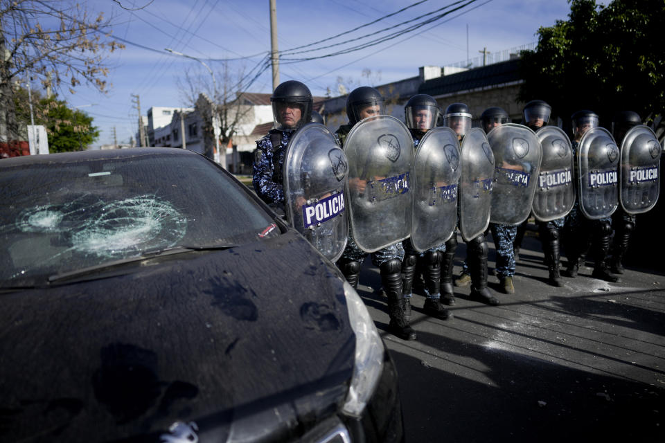 Police in riot gear guard a police station as people protest against the death of 11-year-old girl Morena Dominguez, who died from her injuries after criminals tried to rob her, on the outskirts of Buenos Aires, Argentina, Wednesday, Aug. 9, 2023. (AP Photo/Natacha Pisarenko)