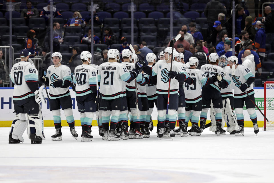 The Seattle Kraken celebrate after defeating the New York Islanders in an NHL hockey game Wednesday, Feb. 2, 2022, in Elmont, N.Y. The Kraken won 3-0. (AP Photo/Adam Hunger)