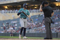 Seattle Mariners' Josh Rojas looks toward the home plate umpire after being called out on strikes to end the top of the third inning of a baseball game against the Minnesota Twins, Monday, May 6, 2024, in Minneapolis. (AP Photo/Abbie Parr)